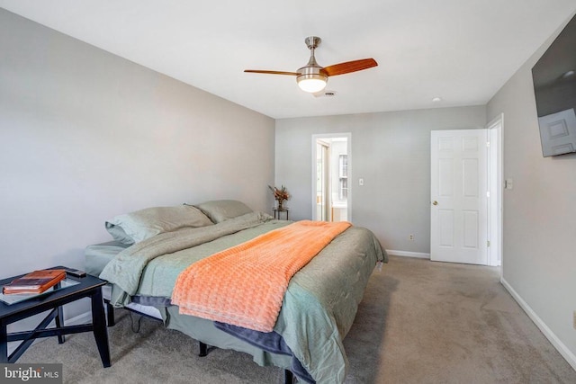 carpeted bedroom with a ceiling fan, baseboards, and ensuite bathroom