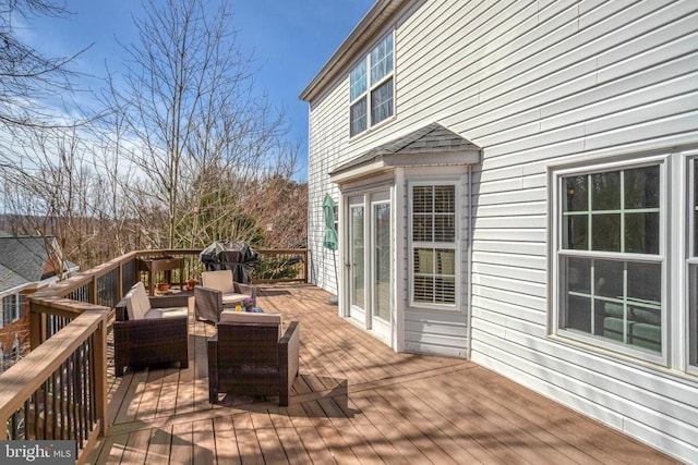 wooden terrace featuring an outdoor hangout area and a grill