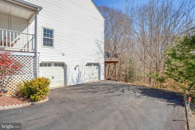 view of property exterior with a garage and aphalt driveway