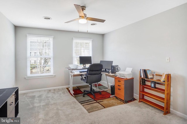 carpeted office with visible vents, baseboards, and a ceiling fan