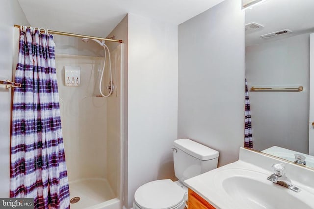 bathroom with visible vents, vanity, toilet, and a shower stall