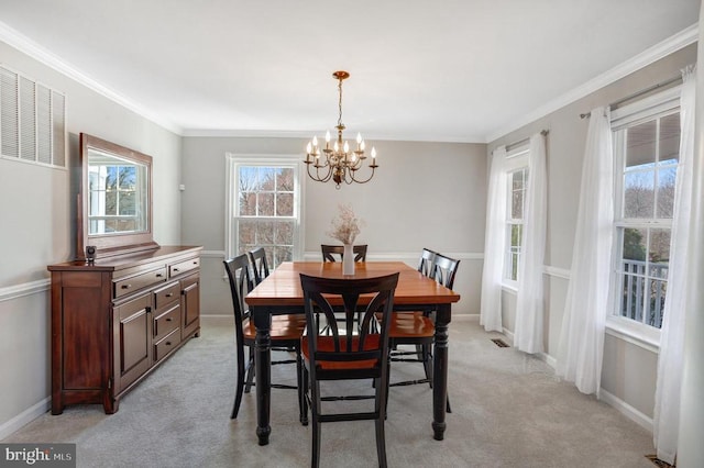 dining area featuring baseboards, light carpet, a chandelier, and ornamental molding