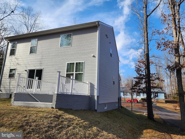 rear view of house featuring a deck and a yard