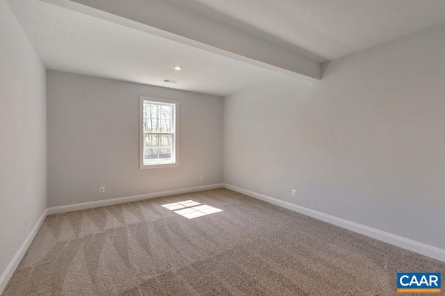 carpeted spare room featuring beam ceiling