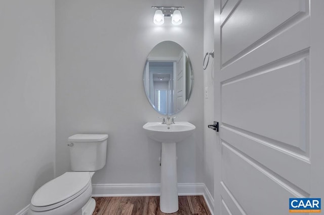 bathroom with toilet and hardwood / wood-style floors