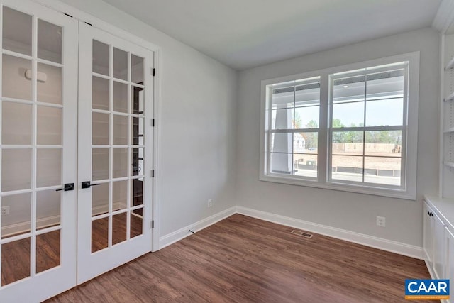 empty room with wood-type flooring and french doors