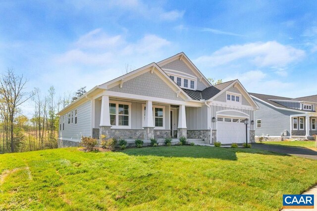 craftsman inspired home with a garage, covered porch, and a front lawn