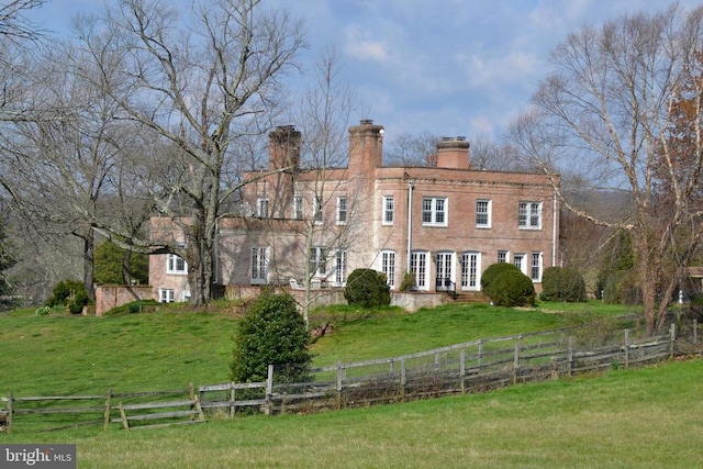 rear view of property featuring a lawn