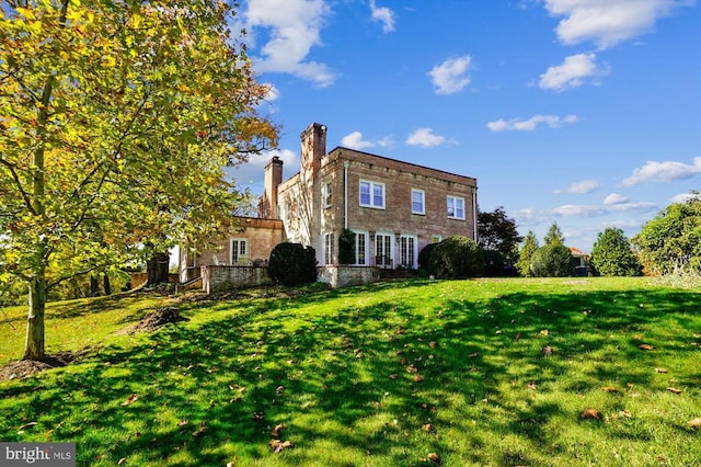 rear view of property with a yard