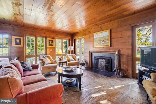 living room featuring wooden walls, wooden ceiling, and a healthy amount of sunlight