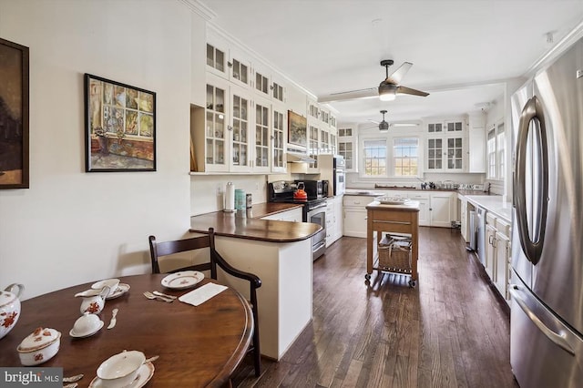 kitchen featuring sink, white cabinetry, stainless steel appliances, a kitchen breakfast bar, and kitchen peninsula