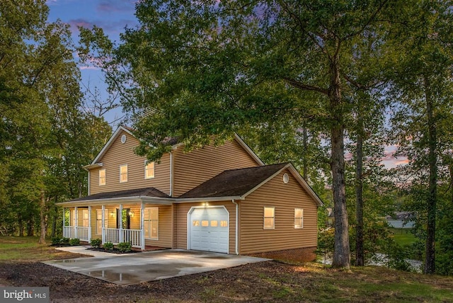 view of front of house featuring a garage, a porch, and concrete driveway