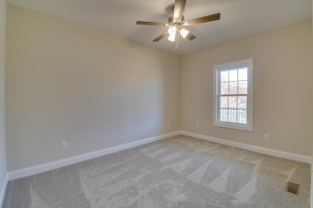 empty room with ceiling fan, visible vents, baseboards, and light carpet