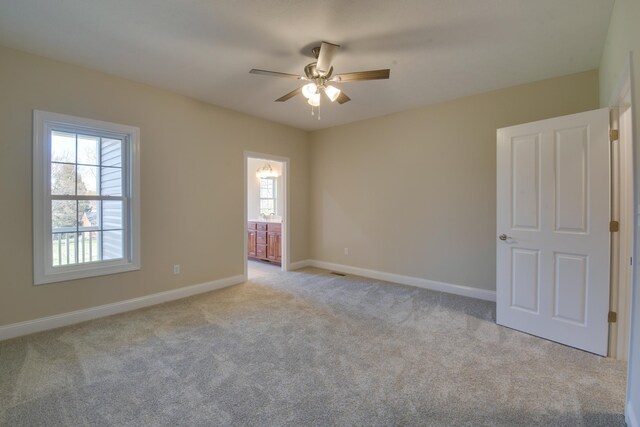 unfurnished room featuring light carpet, a ceiling fan, and baseboards