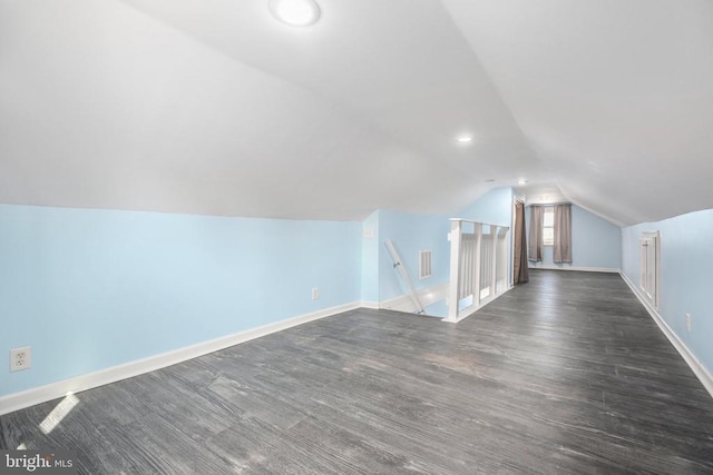 additional living space with recessed lighting, baseboards, dark wood-type flooring, and vaulted ceiling