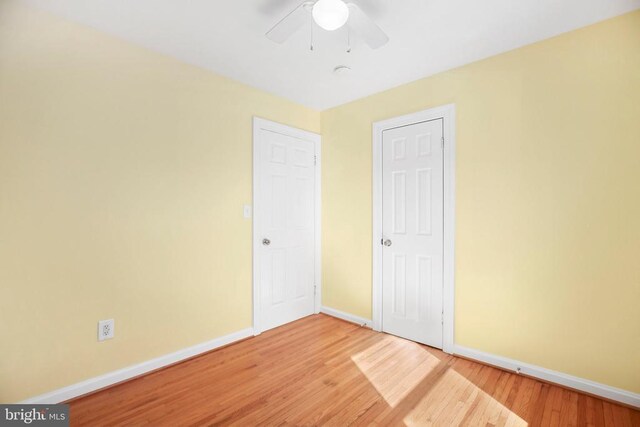 unfurnished bedroom with baseboards, wood finished floors, and a ceiling fan