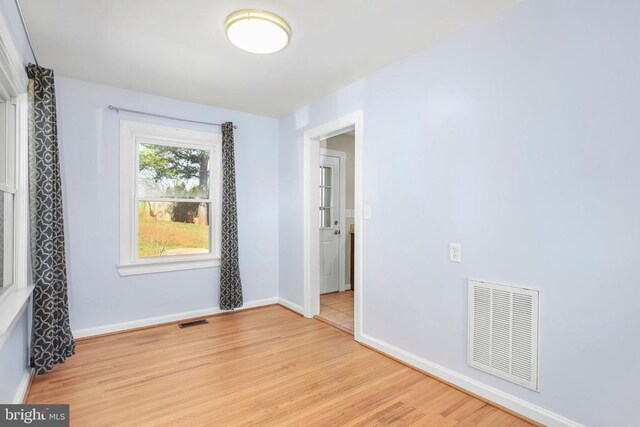 unfurnished room with baseboards, visible vents, and light wood finished floors