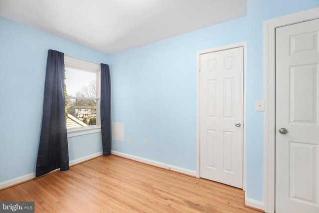 empty room featuring light wood finished floors and baseboards