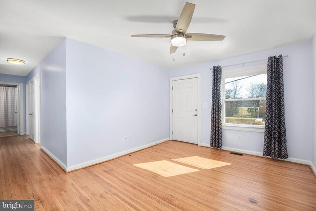 unfurnished room with visible vents, ceiling fan, baseboards, and wood finished floors