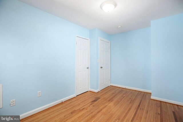 unfurnished room featuring baseboards and wood finished floors