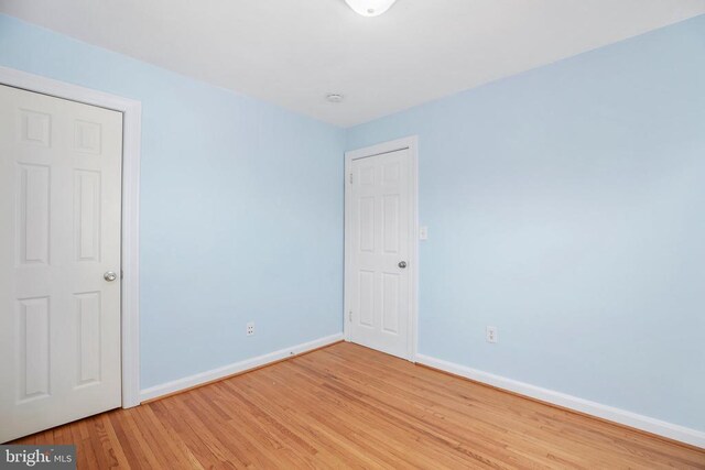 unfurnished room with baseboards and light wood-style floors