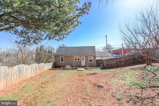 back of property with a deck and a fenced backyard