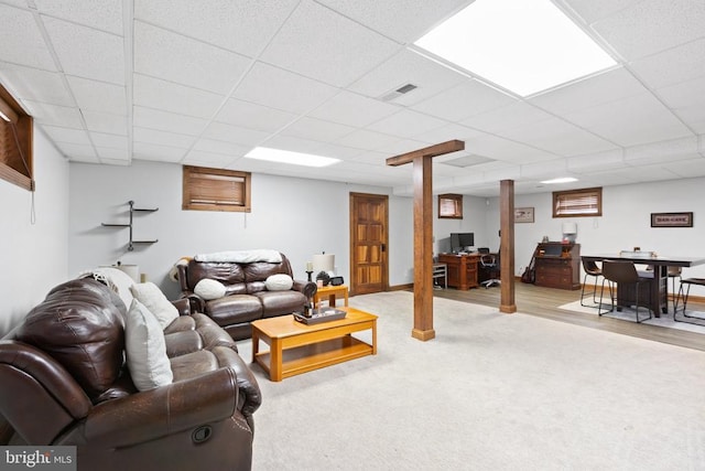 living room featuring light carpet and a paneled ceiling