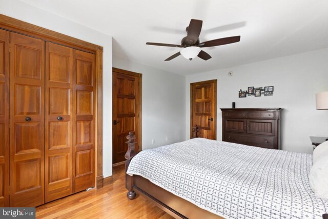 bedroom featuring ceiling fan, a closet, and light hardwood / wood-style flooring