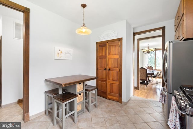 dining room with light tile patterned flooring and a chandelier