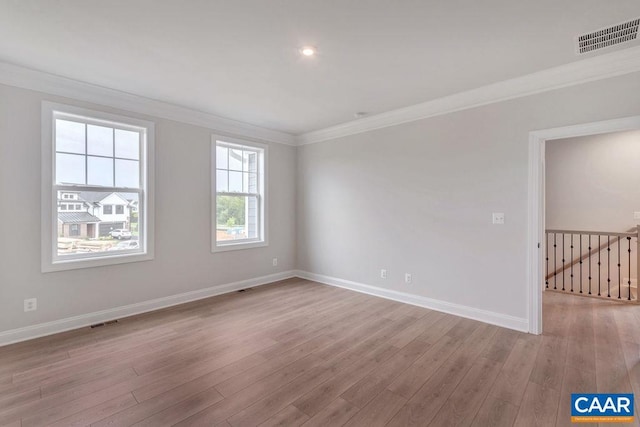 unfurnished room featuring ornamental molding and light wood-type flooring