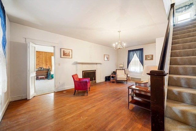 sitting room with hardwood / wood-style floors and an inviting chandelier