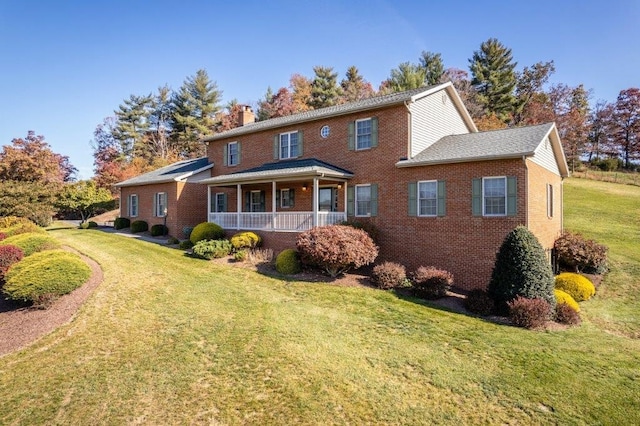 view of front of property with covered porch and a front lawn