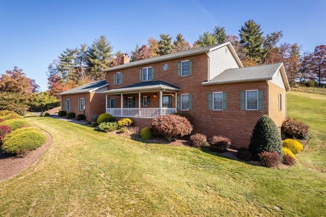 view of front of property with covered porch and a front lawn