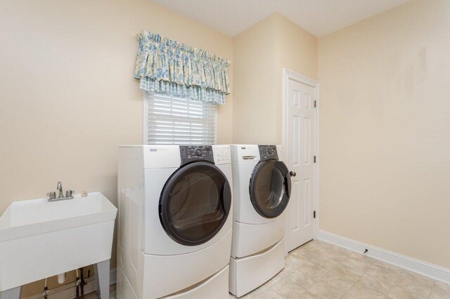 washroom with separate washer and dryer and sink