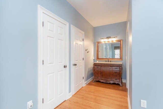 hall with sink and light hardwood / wood-style flooring