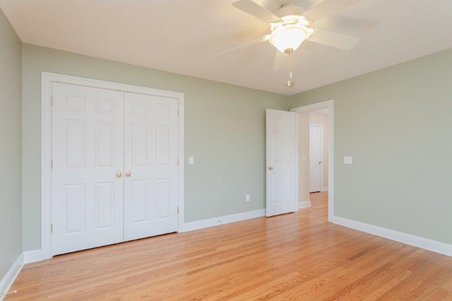 unfurnished bedroom with ceiling fan, light wood-type flooring, and a closet