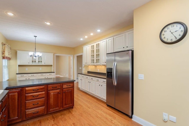 kitchen with an inviting chandelier, hanging light fixtures, stainless steel refrigerator with ice dispenser, white cabinets, and light wood-type flooring