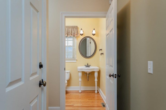 bathroom with hardwood / wood-style floors and toilet