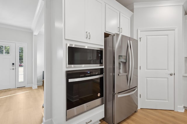 kitchen featuring baseboards, light wood-type flooring, ornamental molding, appliances with stainless steel finishes, and white cabinetry