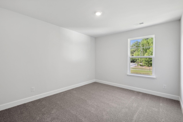 empty room featuring visible vents, baseboards, and carpet