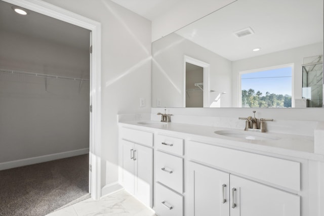 full bathroom with a walk in closet, visible vents, marble finish floor, and a sink