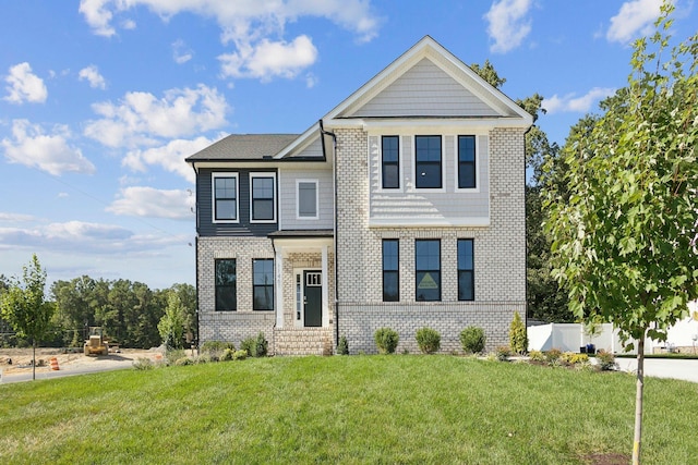 view of front of home with brick siding and a front lawn