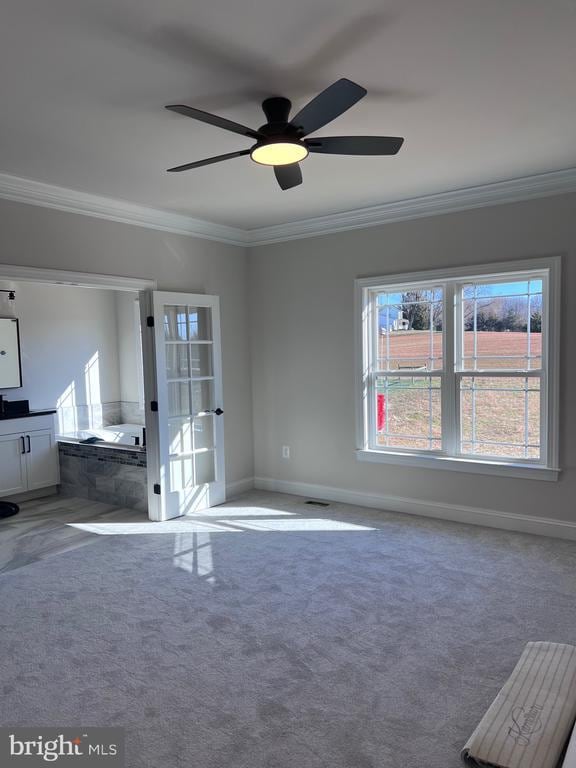 interior space featuring ornamental molding, ceiling fan, and carpet flooring