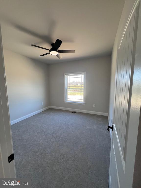 carpeted empty room with ceiling fan