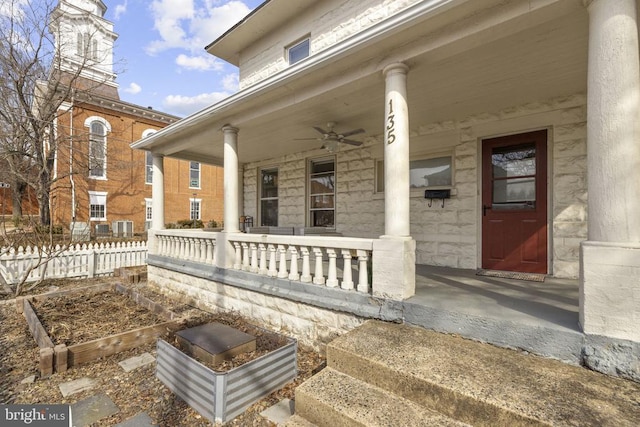 view of exterior entry with a ceiling fan and covered porch