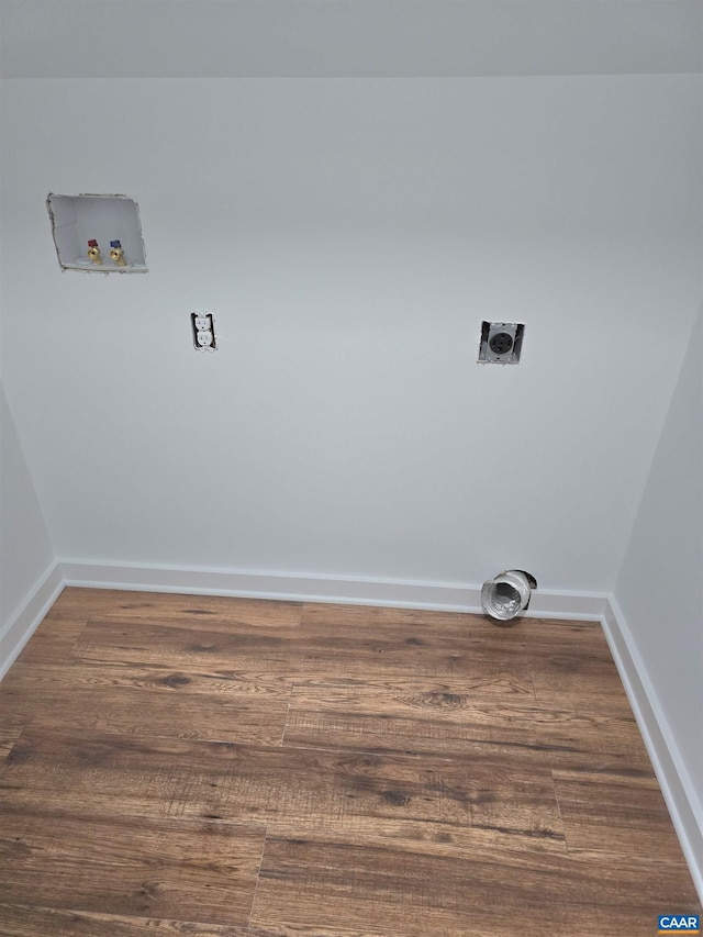 clothes washing area featuring electric dryer hookup, wood finished floors, baseboards, hookup for a washing machine, and laundry area