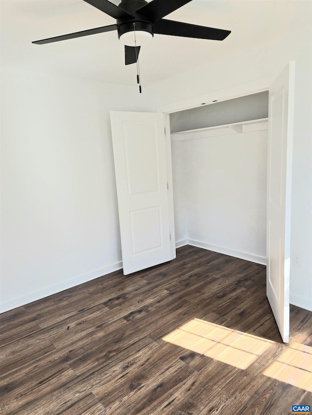 unfurnished bedroom featuring a closet, a ceiling fan, baseboards, and wood finished floors