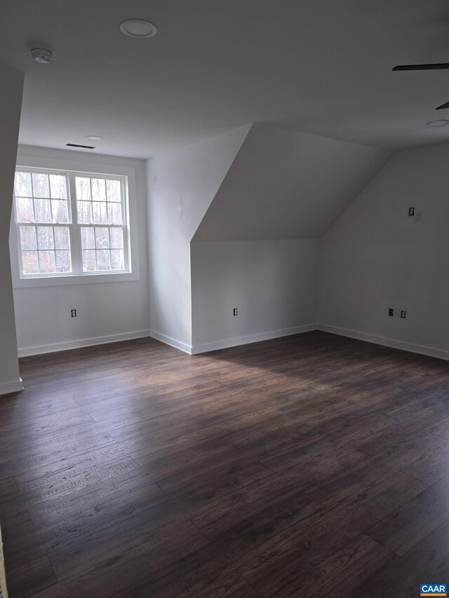 bonus room featuring vaulted ceiling, baseboards, and dark wood-style flooring