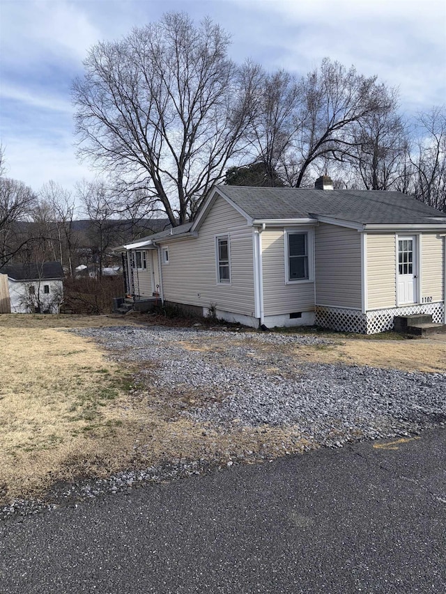 view of front of house featuring entry steps, an outbuilding, and crawl space