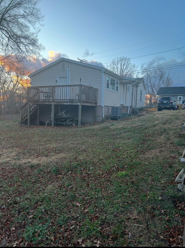 exterior space with a lawn, a deck, and stairs